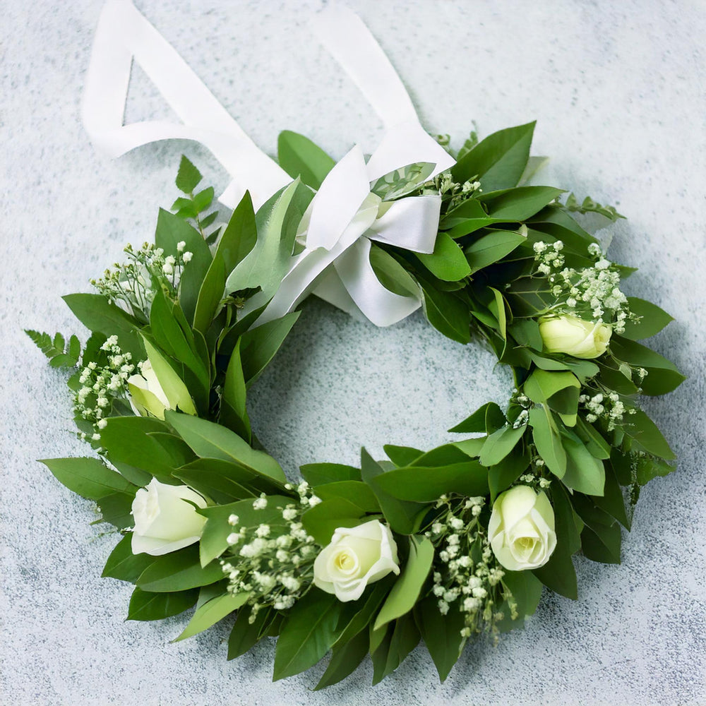 Corona con rose bianche, gypsophila e nastro di raso | Consegna Fiori a Domicilio per Laurea